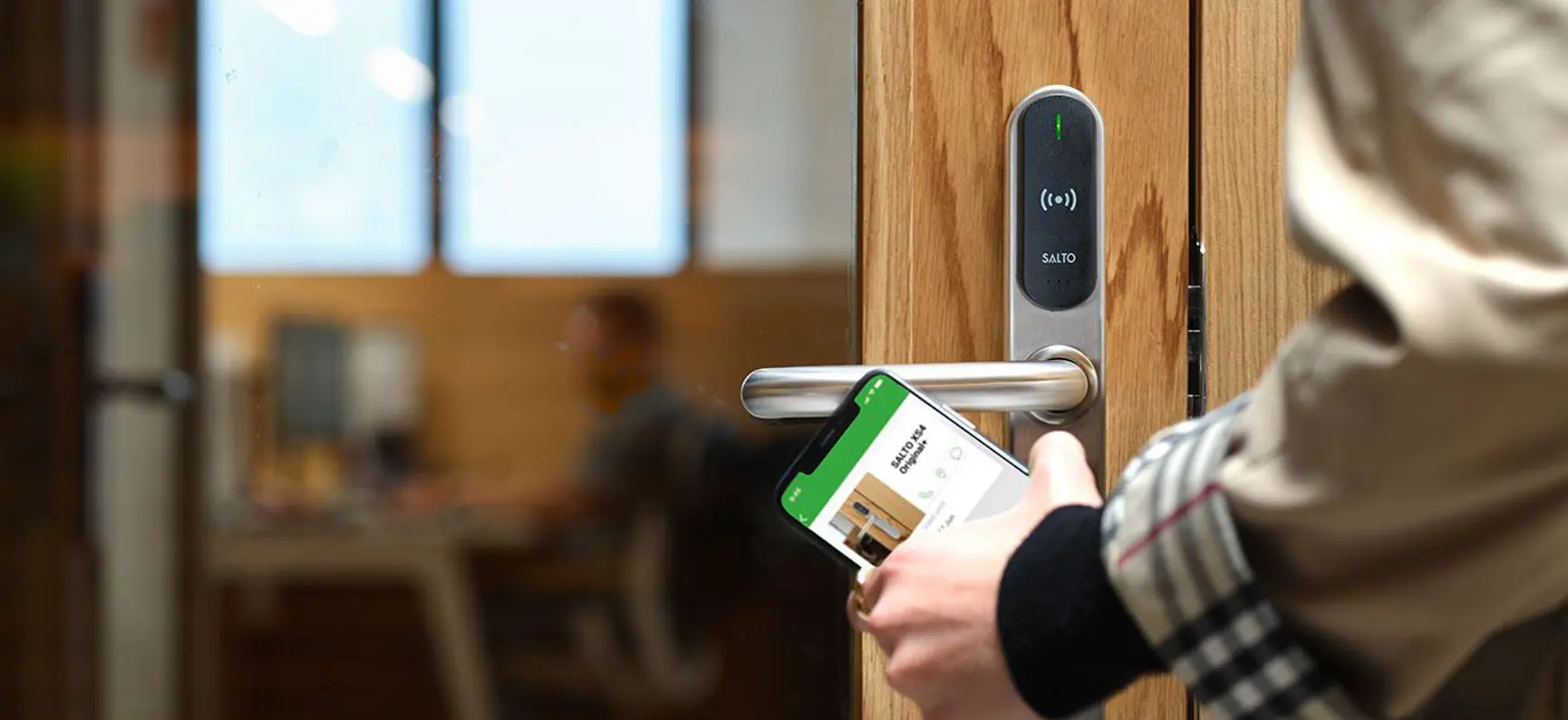 SALTO XS4 smart door lock being opened with the SALTO mobile app on a phone