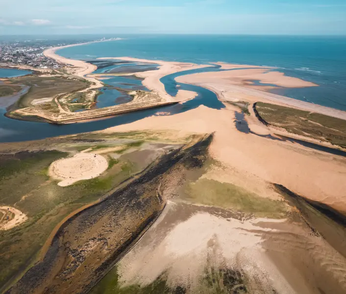 Aerial view of Christchurch Harbour and Mudeford Sandbank, Dorset, with tidal sand flats and the English Channel beyond.