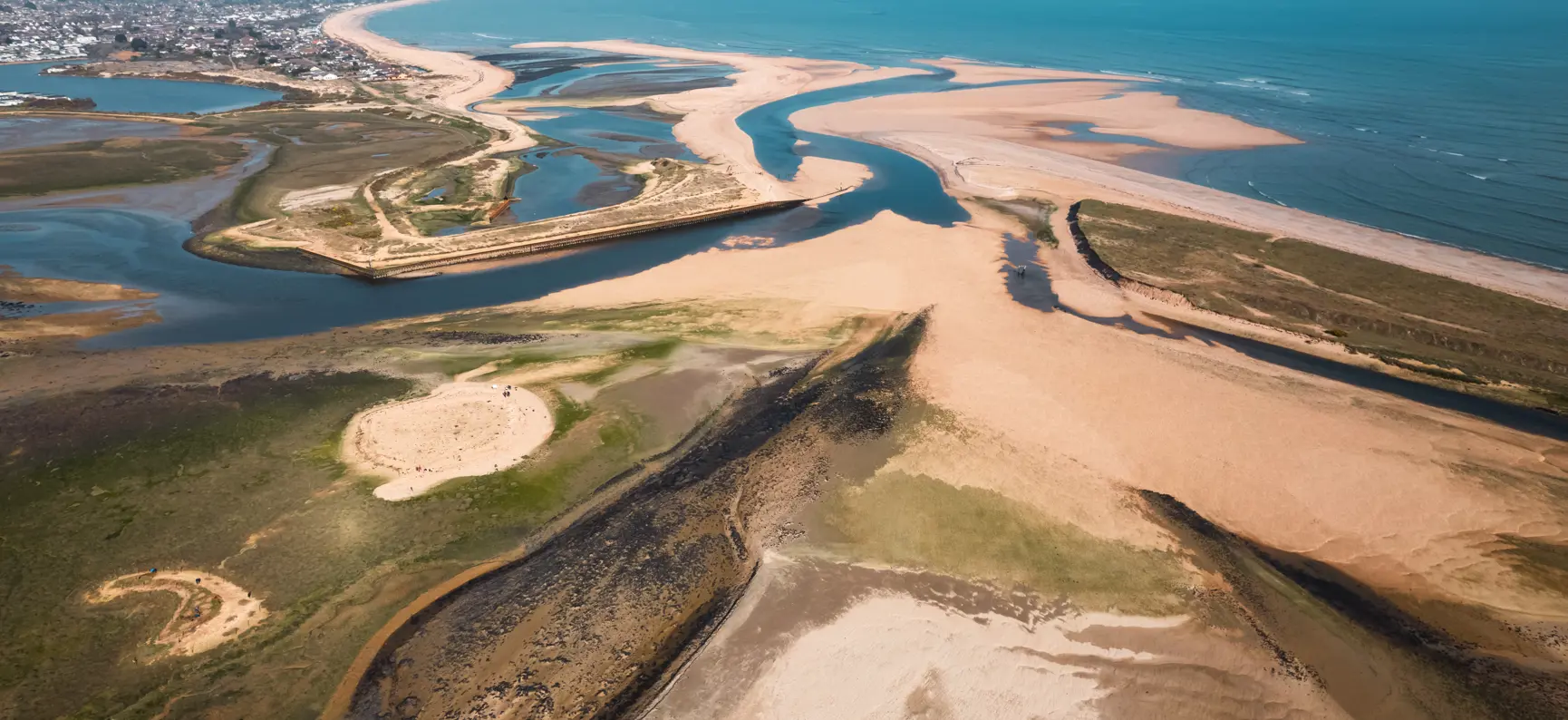 Aerial view of Christchurch Harbour and Mudeford Sandbank, Dorset, with tidal sand flats and the English Channel beyond.