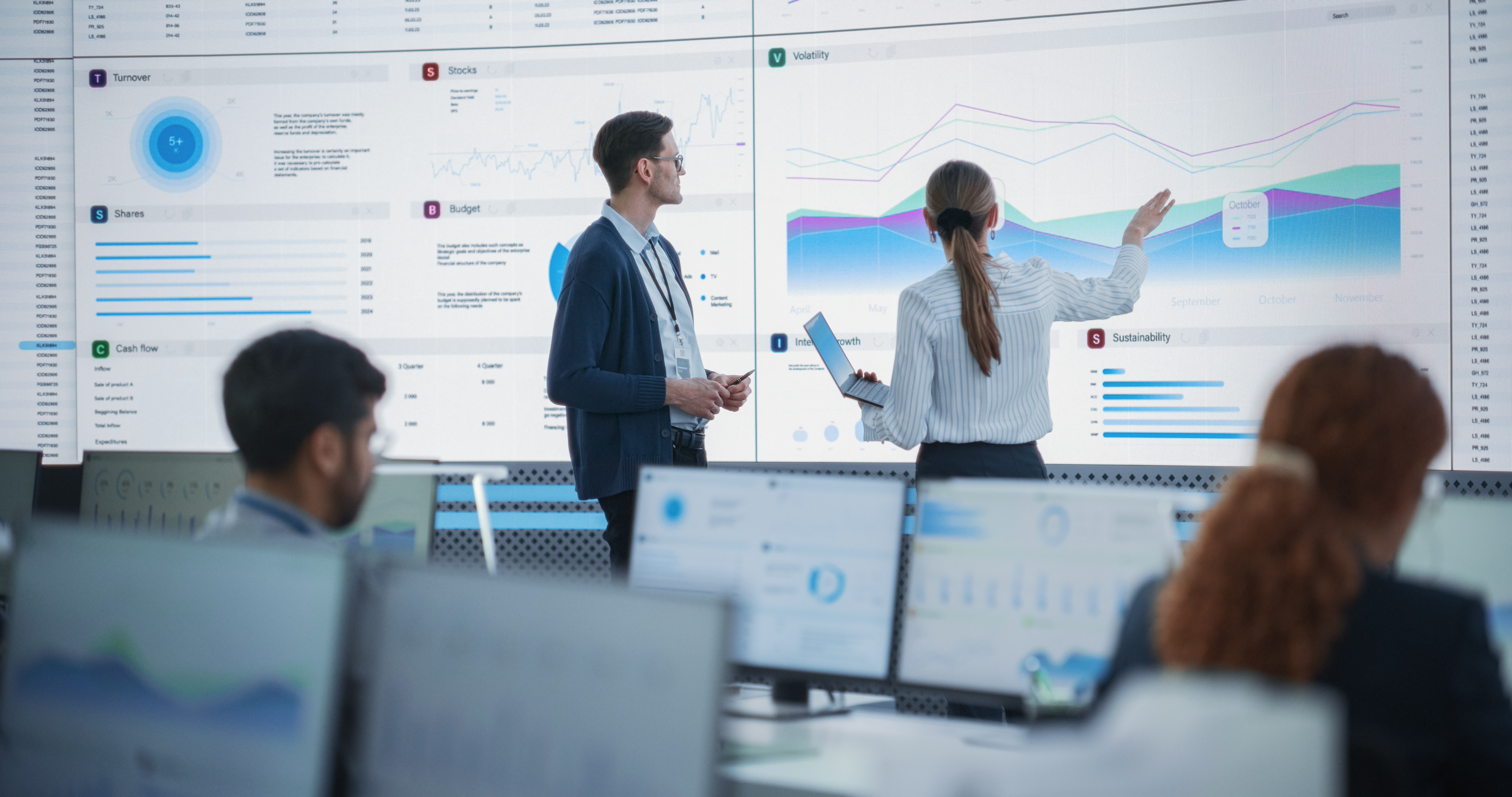 Man and woman looking at very large graph on a screen