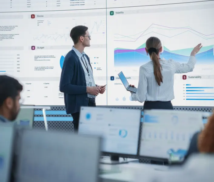Man and woman looking at very large graph on a screen